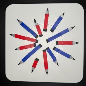 Op de afbeelding: Een wit rond oppervlak met 12 potloden in een cirkel gerangschikt. De potloden wisselen elkaar af in de kleuren rood en blauw.