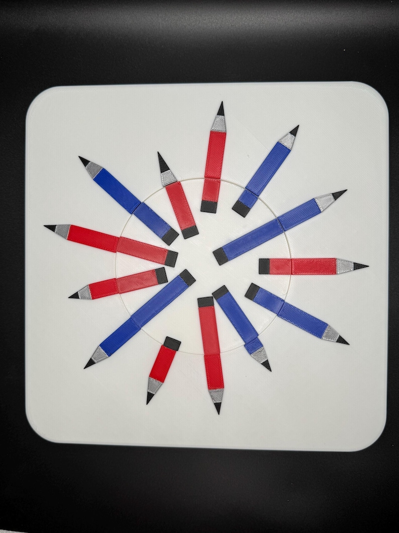 Op de afbeelding: Een wit rond oppervlak met 12 potloden in een cirkel gerangschikt. De potloden wisselen elkaar af in de kleuren rood en blauw.