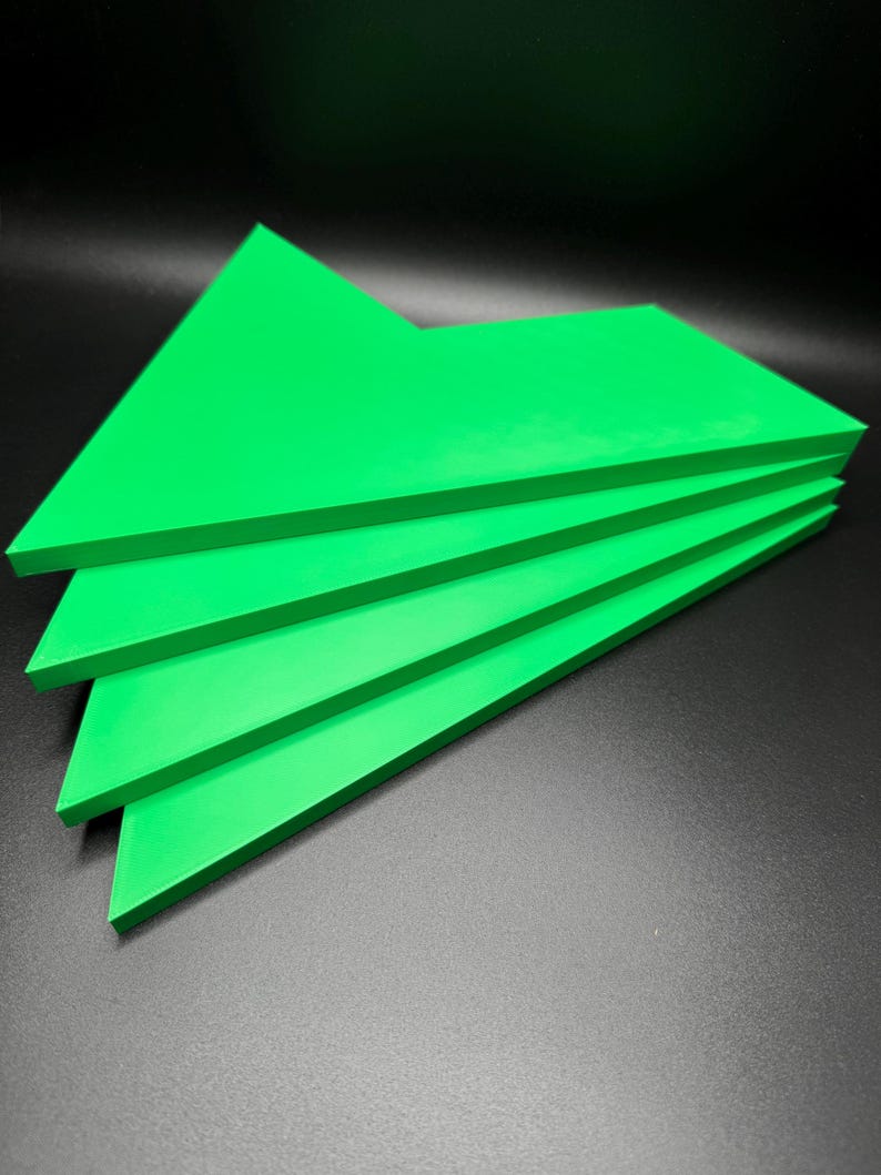 May include: Stack of four bright green triangular shaped pieces of foam board.