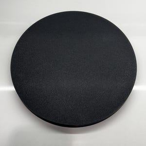 May include: A black, round, foam sanding pad.