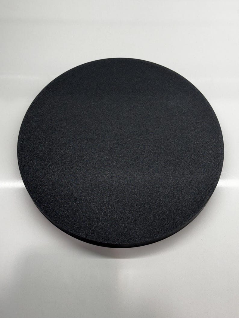 May include: A black, round, foam sanding pad.