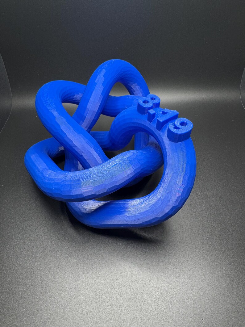 May include: A blue 3D printed knot sculpture with the number "819" printed on the side.