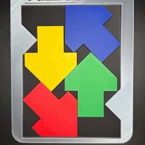 Pu&ograve; includere: Un puzzle colorato con la parola "Puzzle" in alto. Il puzzle presenta quattro pezzi a forma di freccia in rosso, giallo, verde e blu, disposti all'interno di una cornice grigia su sfondo nero.