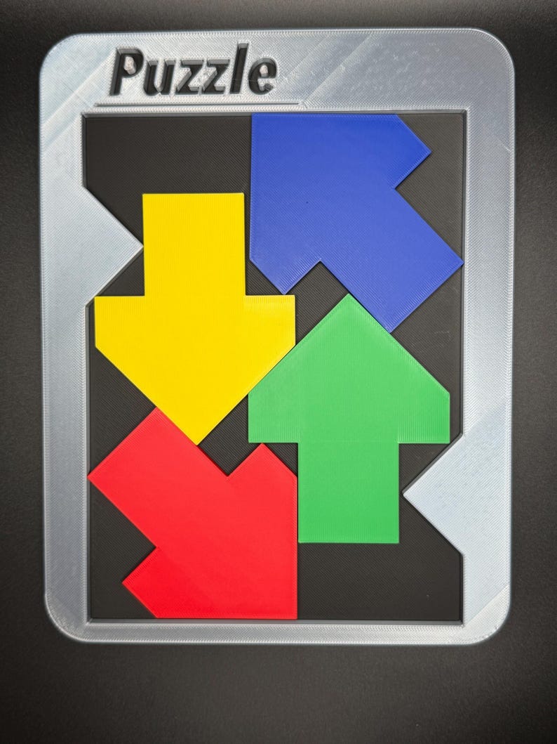 Pu&ograve; includere: Un puzzle colorato con la parola "Puzzle" in alto. Il puzzle presenta quattro pezzi a forma di freccia in rosso, giallo, verde e blu, disposti all'interno di una cornice grigia su sfondo nero.