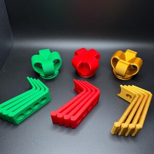 May include: Three sets of 3D printed plastic pieces in green, red, and gold. Each set includes a crown-shaped piece and five curved pieces.