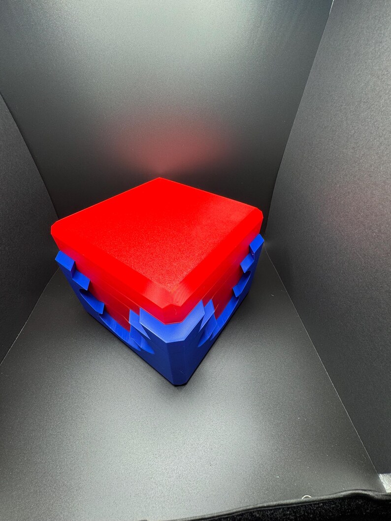May include: A red and blue box with a geometric design. The box is closed and has a smooth, glossy finish.