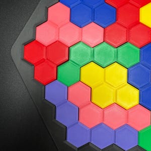 May include: A hexagonal puzzle with colorful pieces in shades of blue, red, green, yellow, pink, and purple. The pieces fit together to create a larger hexagonal shape.