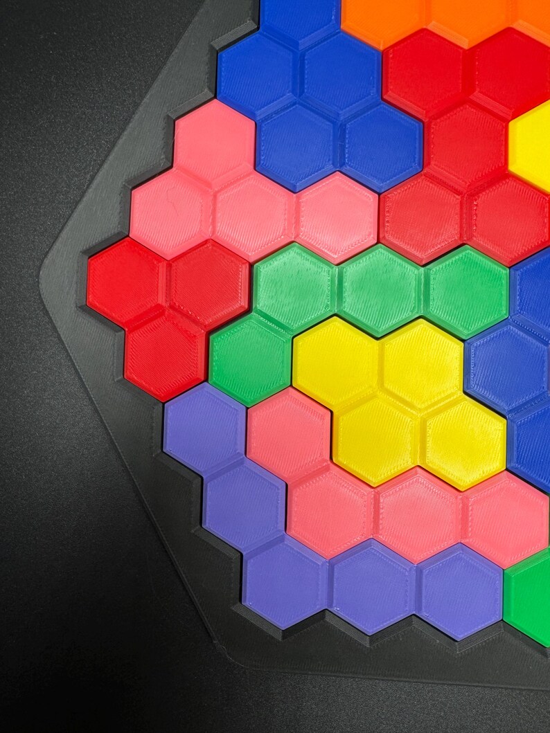 May include: A hexagonal puzzle with colorful pieces in shades of blue, red, green, yellow, pink, and purple. The pieces fit together to create a larger hexagonal shape.
