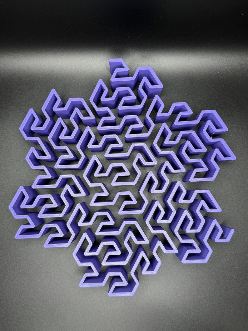 May include: A purple 3D printed snowflake maze with intricate pathways and a complex design.
