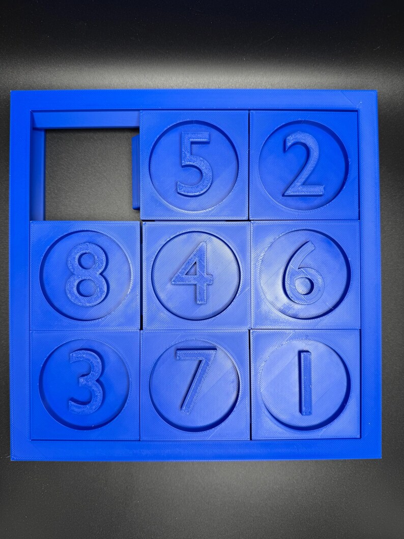May include: A blue plastic puzzle with nine squares, each containing a circle with a number inside. The numbers are 5, 2, 8, 4, 6, 3, 7, and 1. One square is empty.