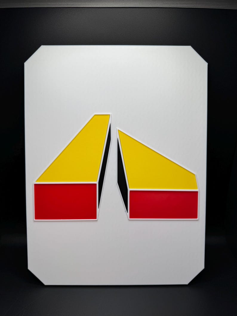 May include: Geometric abstract art piece featuring two angled shapes. The shapes are composed of red, yellow, and black blocks, set against a white background. The artwork is mounted on a white, rectangular board with rounded corners.