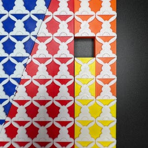 May include: A close-up of a colorful geometric pattern made of square tiles. The tiles are arranged in a diagonal pattern and feature a white bunny rabbit design. The tiles are blue, green, orange, red, and yellow.