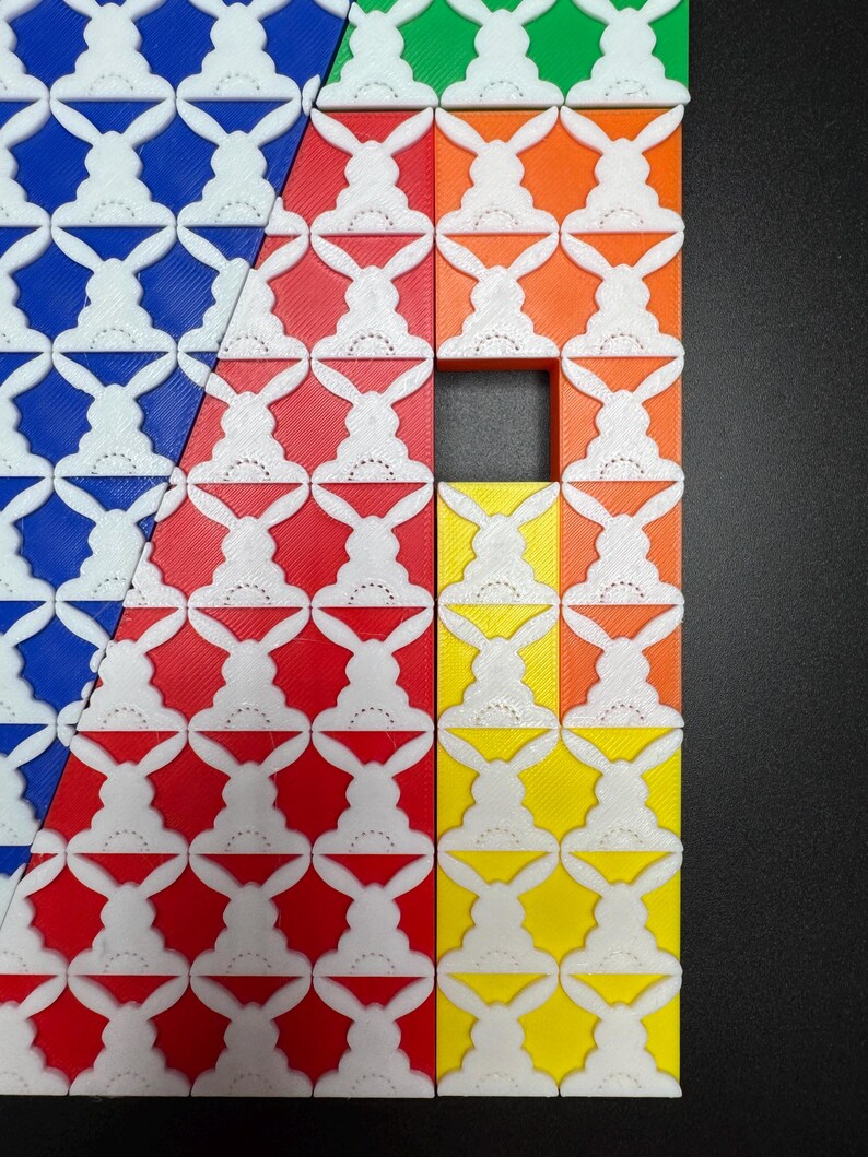 May include: A close-up of a colorful geometric pattern made of square tiles. The tiles are arranged in a diagonal pattern and feature a white bunny rabbit design. The tiles are blue, green, orange, red, and yellow.