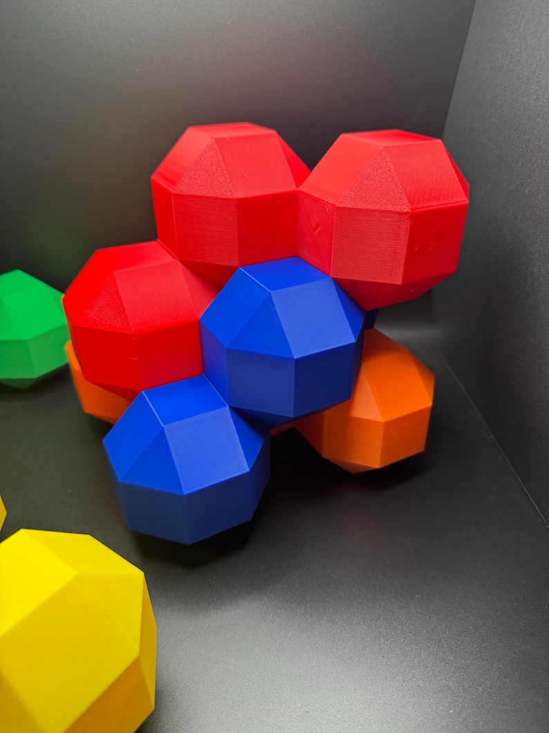 May include: A group of geometric shapes made of plastic in red, blue, orange, and green colors. The shapes are arranged in a cluster, with some overlapping.