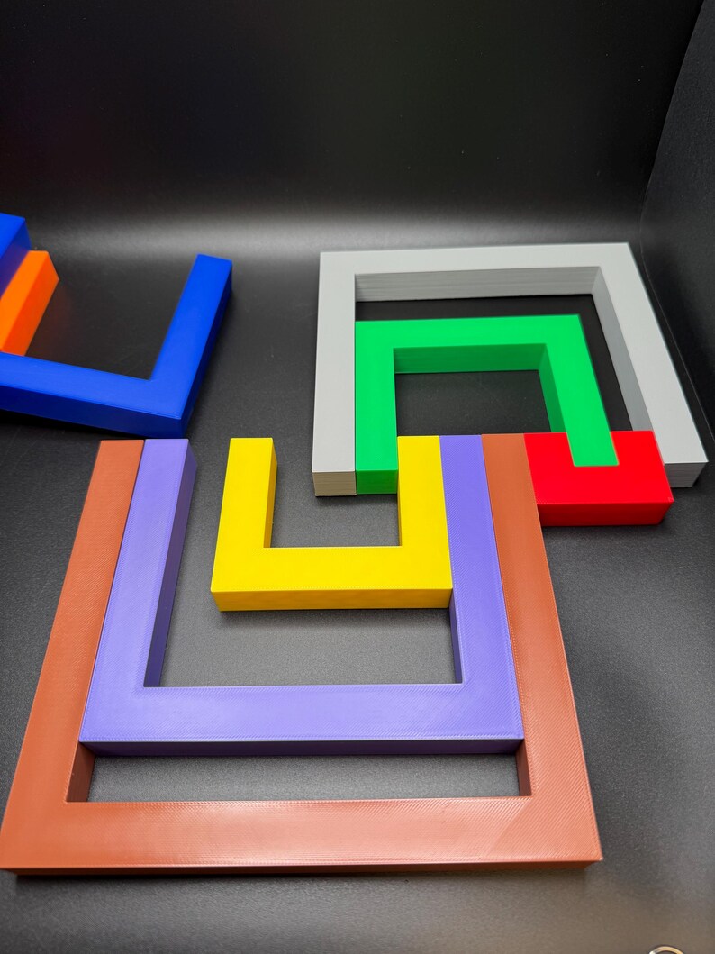 May include: A collection of colorful, geometric puzzle pieces in various shapes and sizes. The pieces are in shades of blue, orange, yellow, green, red, gray, purple, and brown. The puzzle pieces are arranged on a dark surface.