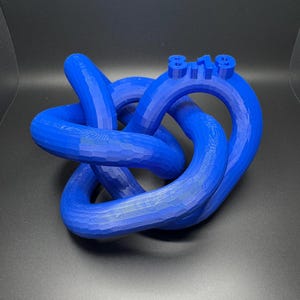 May include: A blue 3D printed knot sculpture with the number "819" printed on the top.