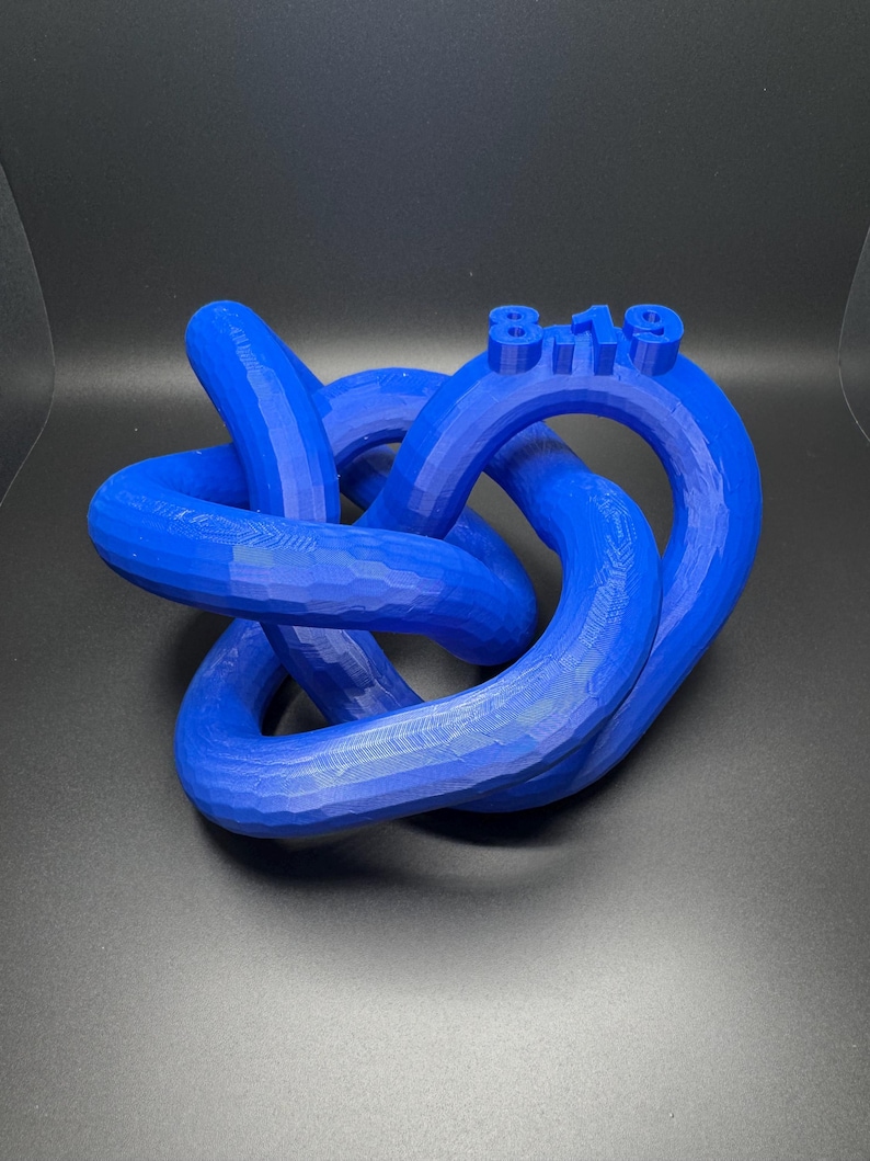 May include: A blue 3D printed knot sculpture with the number "819" printed on the top.