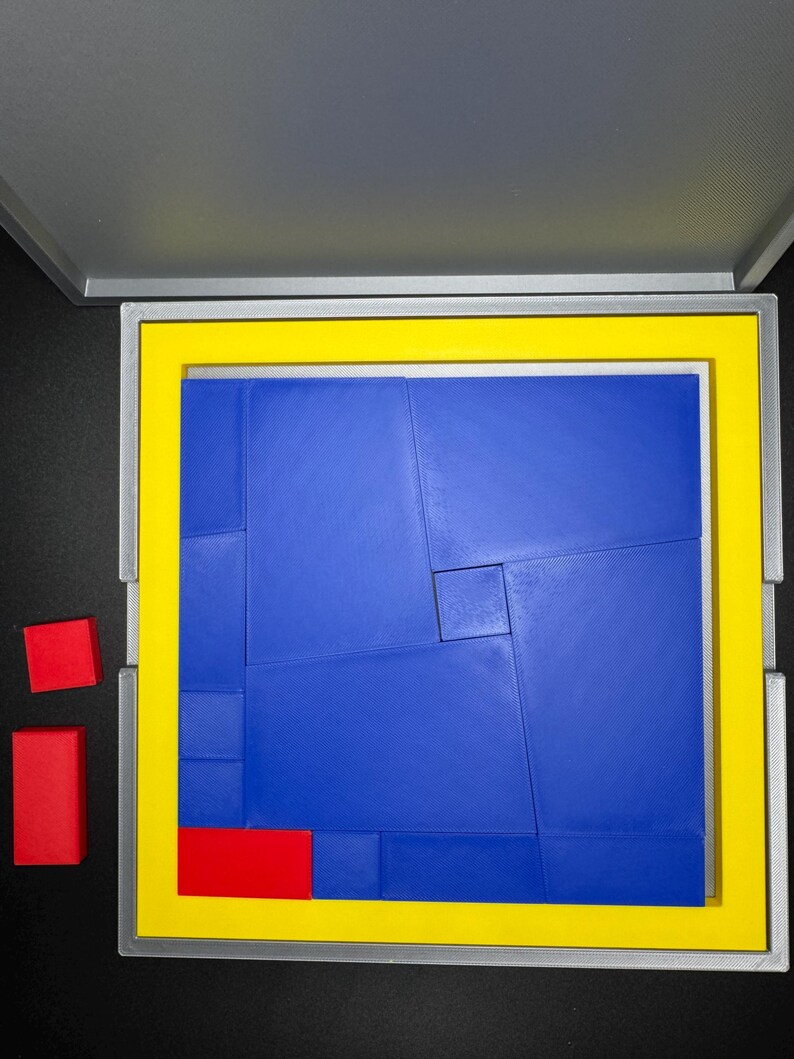 May include: A blue puzzle with 12 pieces in a gray box with a yellow border. There are three red pieces outside the box.