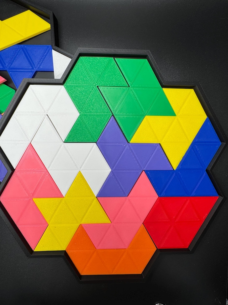 May include: A colorful geometric puzzle with triangular pieces in shades of green, yellow, blue, purple, pink, orange, red, and white. The pieces fit together to form a hexagonal shape.