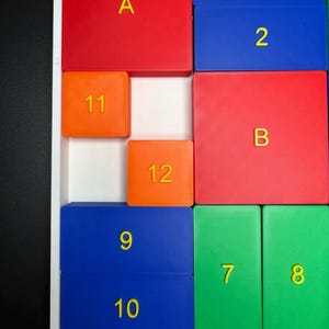 May include: A colorful puzzle with numbered and lettered tiles. The tiles are arranged in a grid pattern. The numbers 1, 2, 7, 8, 9, 10, 11, and 12 are visible. The letters A and B are also visible.