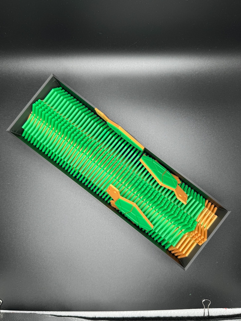 May include: A close-up of a green and gold circuit board with many small components. The board is arranged in a grid pattern and is surrounded by a black background.