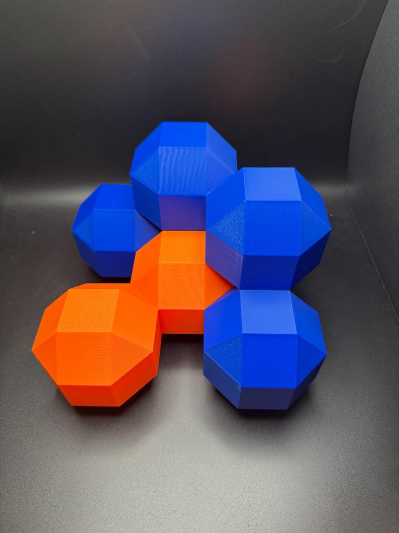 May include: A group of geometric shapes made of 3D printed plastic. The shapes are arranged in a cluster, with some overlapping. The shapes are blue and orange.