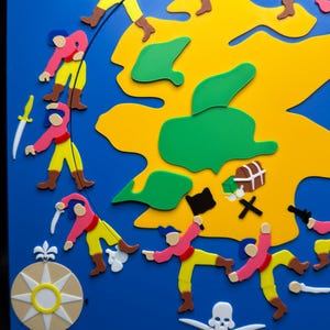 May include: A colorful pirate-themed artwork on a blue background. The design features a yellow island, green landmasses, and cartoon pirates in pink and yellow attire. Includes a compass rose, treasure chest, skull and crossbones, and swords.