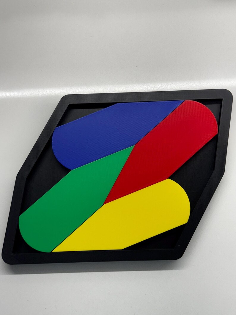Op de afbeelding: Een geometrische puzzel met vier stukken in een zwart frame. De stukken zijn gevormd als gebogen rechthoeken en zijn rood, blauw, groen en geel gekleurd.
