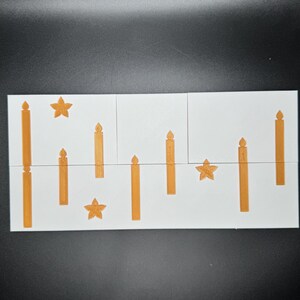 Puede incluir: Una tarjeta blanca con dise&ntilde;os de velas y estrellas naranjas. Las velas var&iacute;an en altura y est&aacute;n dispuestas verticalmente. Las estrellas tienen cinco puntas. La tarjeta est&aacute; dividida en tres secciones.