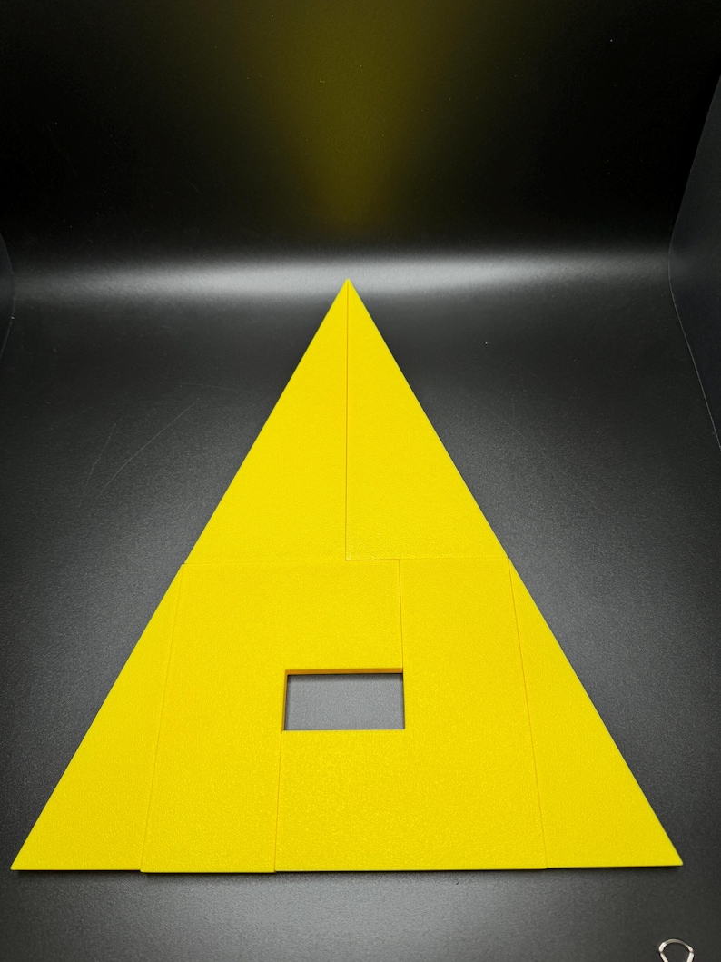 May include: A yellow triangle-shaped puzzle made of multiple pieces. The puzzle has a rectangular hole in the center.