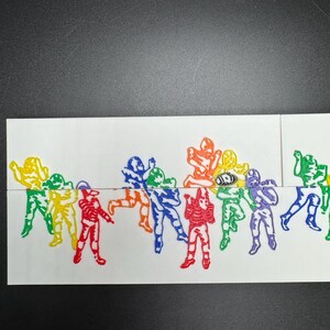 Pu&ograve; includere: Una fila di figurine di giocatori di football americano stampate in 3D di vari colori. Le figurine sono disposte in fila e sono di diversi colori, tra cui giallo, rosso, verde, blu, viola e nero.