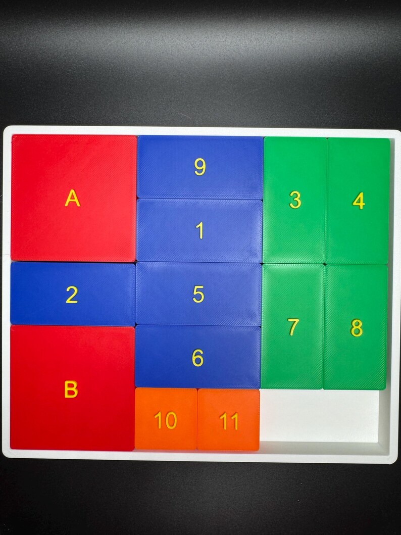 May include: A white tray with a puzzle game made of colorful tiles. The tiles are red, blue, green, and orange. The tiles have numbers and letters on them. The numbers are 1, 2, 3, 4, 5, 6, 7, 8, 9, 10, and 11. The letters are A and B.