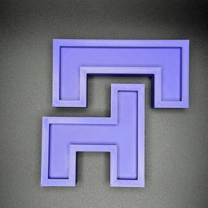 May include: A purple plastic 3D printed puzzle with a complex interlocking design. The puzzle is made up of two pieces that fit together to form a larger shape.