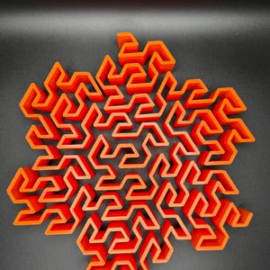 May include: A 3D printed orange geometric maze in the shape of a snowflake.