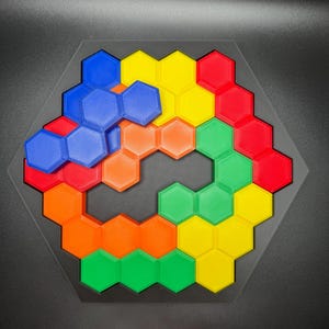 May include: A hexagonal puzzle with a honeycomb design. The puzzle is made up of 18 pieces in four colors: blue, orange, yellow, and green.