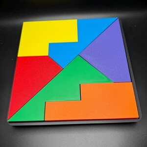 May include: A wooden puzzle with seven pieces in different colors: yellow, blue, red, green, orange, and purple. The pieces fit together to form a square.