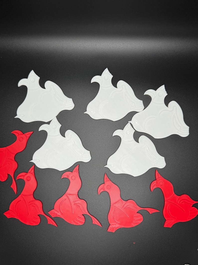 May include: A set of 10 white and red ceramic bird ornaments. The birds are in a variety of poses, with some facing forward and others facing sideways. The ornaments are all about 3 inches tall.