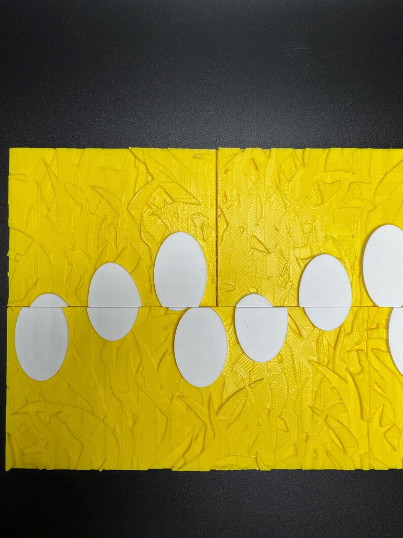 May include: A yellow textured surface with a row of white circles cut out. The circles are arranged in a staggered pattern.