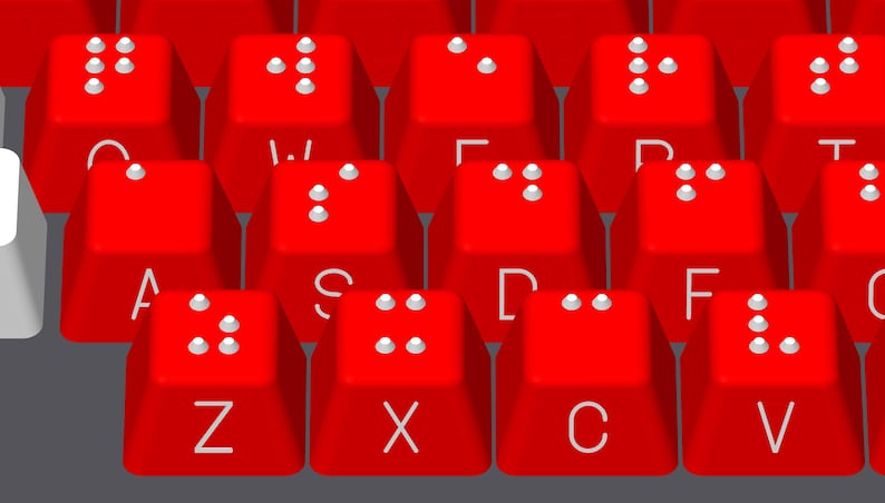 May include: Red keyboard with white keys and braille dots on each key. The keys are labeled with letters of the alphabet.
