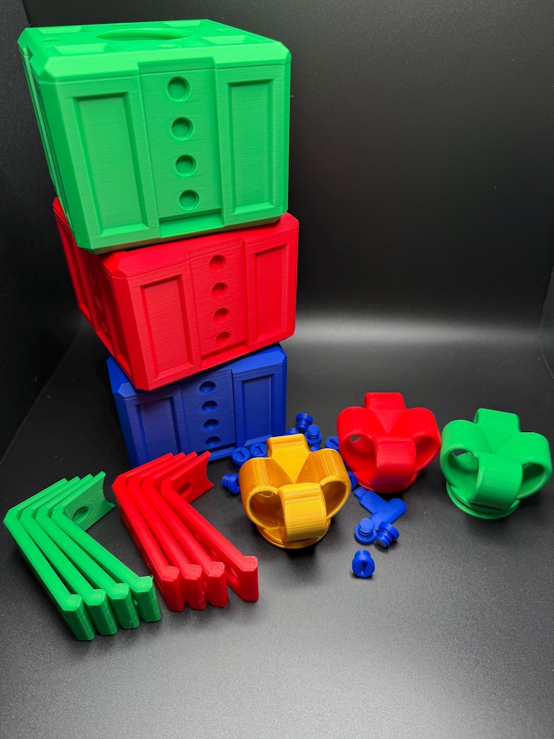 May include: A set of colorful 3D printed building blocks, including green, red, blue, yellow, and orange pieces. The blocks are stacked on top of each other, and there are also some smaller pieces, such as brackets and connectors.