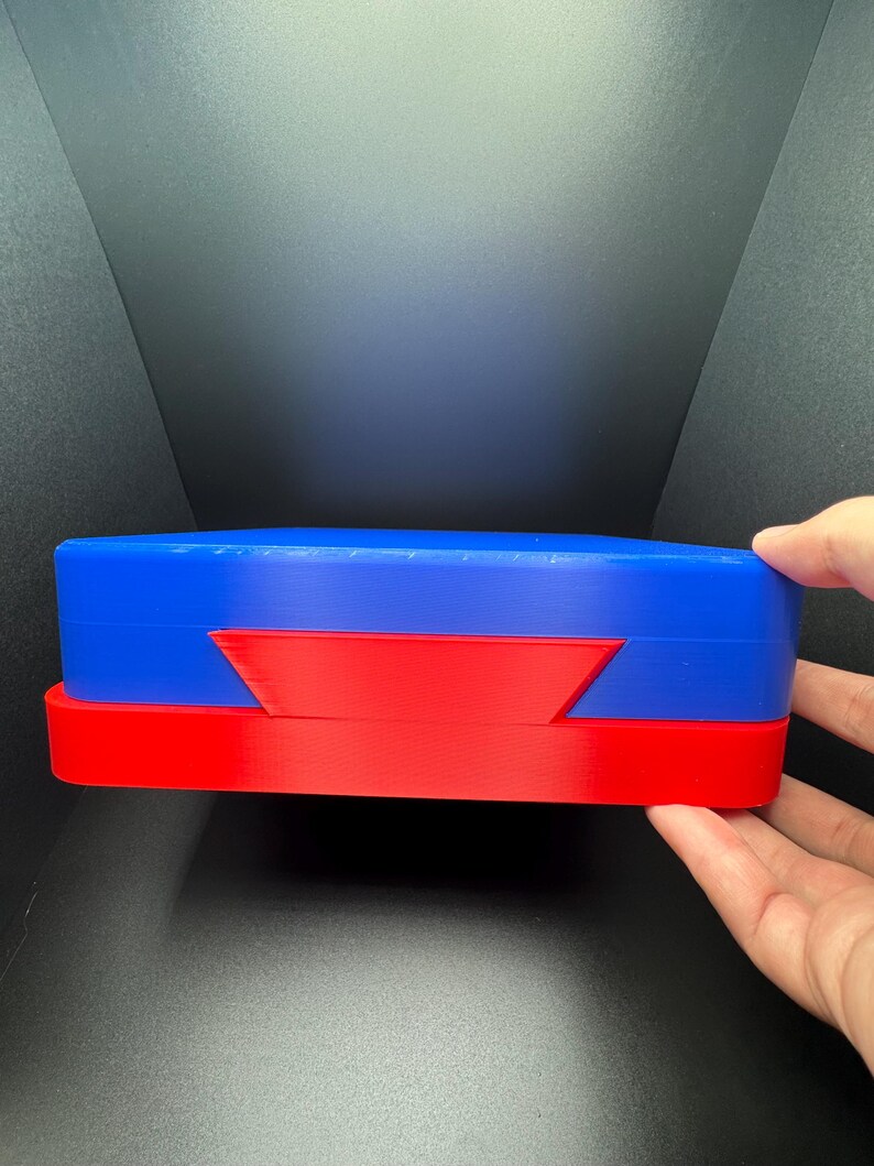 May include: Two stacked, oval-shaped boxes. The top box is blue and the bottom box is red.