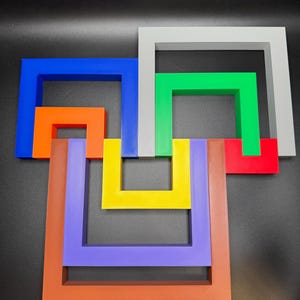 May include: An abstract art piece featuring interlocking square frames in various colors. The colors include blue, orange, brown, purple, yellow, green, red, and gray. The artwork is displayed against a black background.