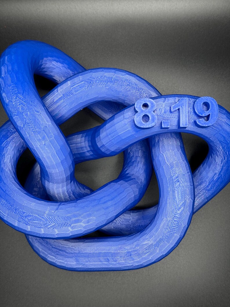 May include: A blue 3D printed knot with the numbers 8-19 printed on it.
