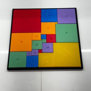 May include: A colorful square puzzle with numbers on each piece. The puzzle is made up of 16 squares, each with a different color and number. The colors include red, orange, yellow, green, blue, purple, and brown.