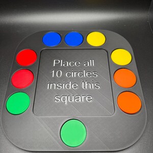 K&ouml;nnte beinhalten: Ein graues Puzzlespiel mit zehn farbigen Kreisen: rot, gr&uuml;n, blau, gelb und orange. Der Text auf dem Spiel lautet: "Platzieren Sie alle 10 Kreise in diesem Quadrat."