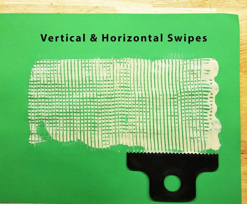 May include: A white paint or paste is spread on a green surface using a black comb-like tool. The paint is spread in a grid pattern with vertical and horizontal lines. The text "Vertical & Horizontal Swipes" is at the top of the image.