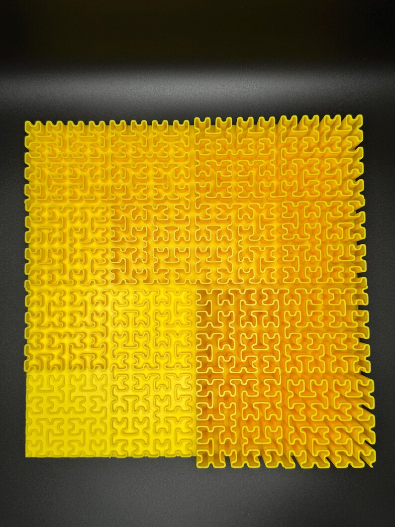May include: A yellow interlocking puzzle mat made of plastic. The mat is made up of small squares that fit together to create a larger surface.