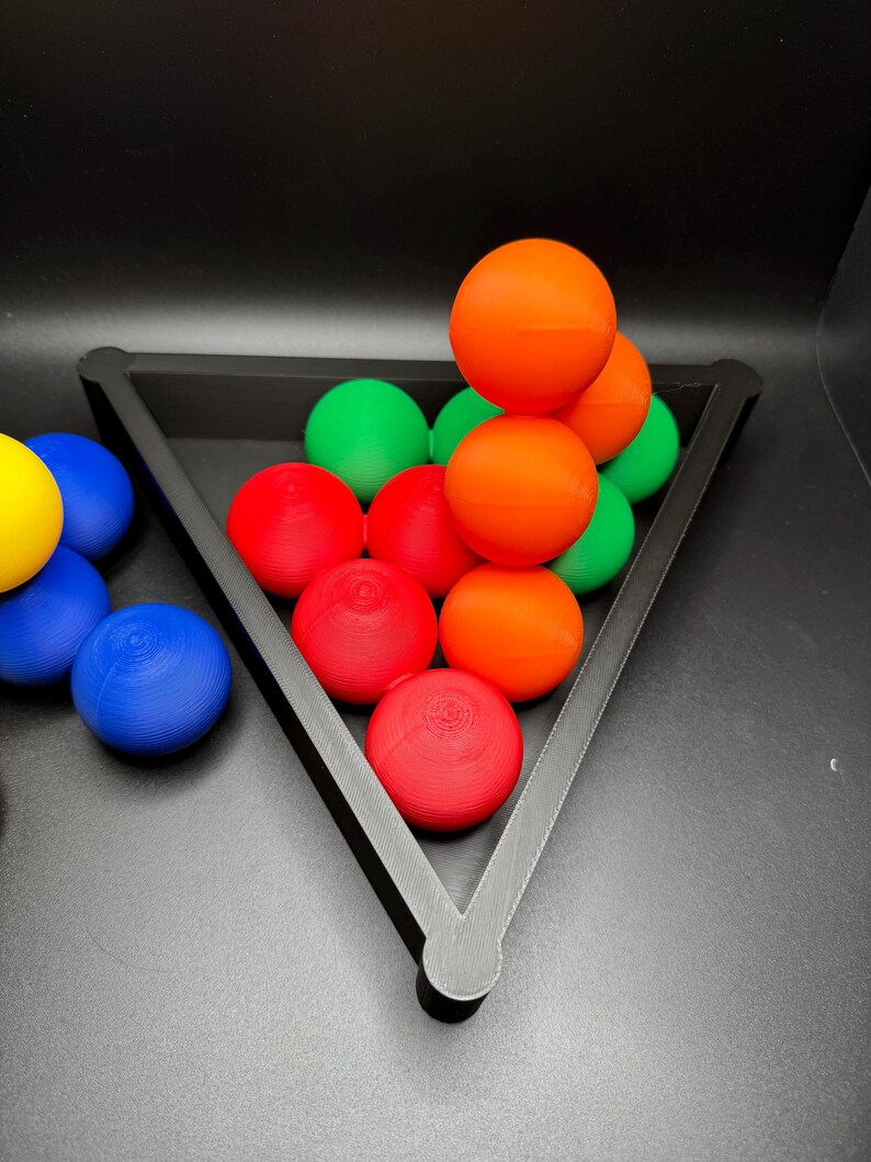 Peut inclure: Un rack triangulaire noir contient une pile de boules color&eacute;es. Les boules sont rouges, orange, vertes et bleues. Les boules sont dispos&eacute;es en forme de pyramide.