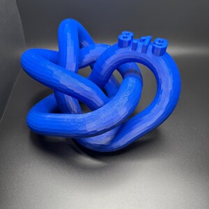 May include: A blue 3D printed knot sculpture with the date "8.19" printed on it.