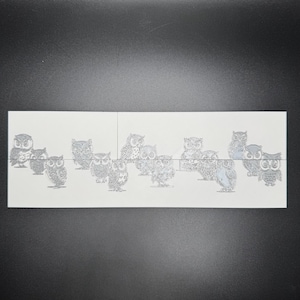 May include: A sheet of white paper with multiple black and white owl illustrations. The owls are in various poses and sizes.